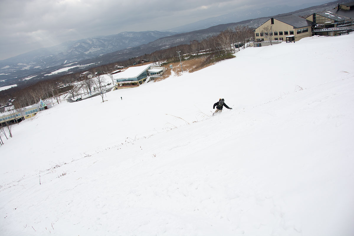 snowboarding in niseko, with annupuri base area in background